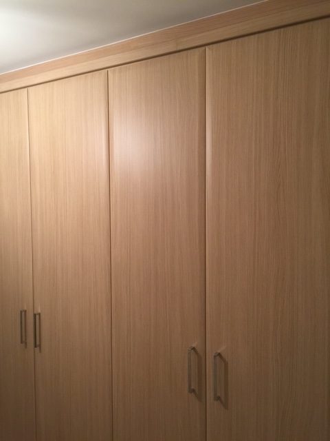 Floor-to-ceiling fitted wardrobes in light oak