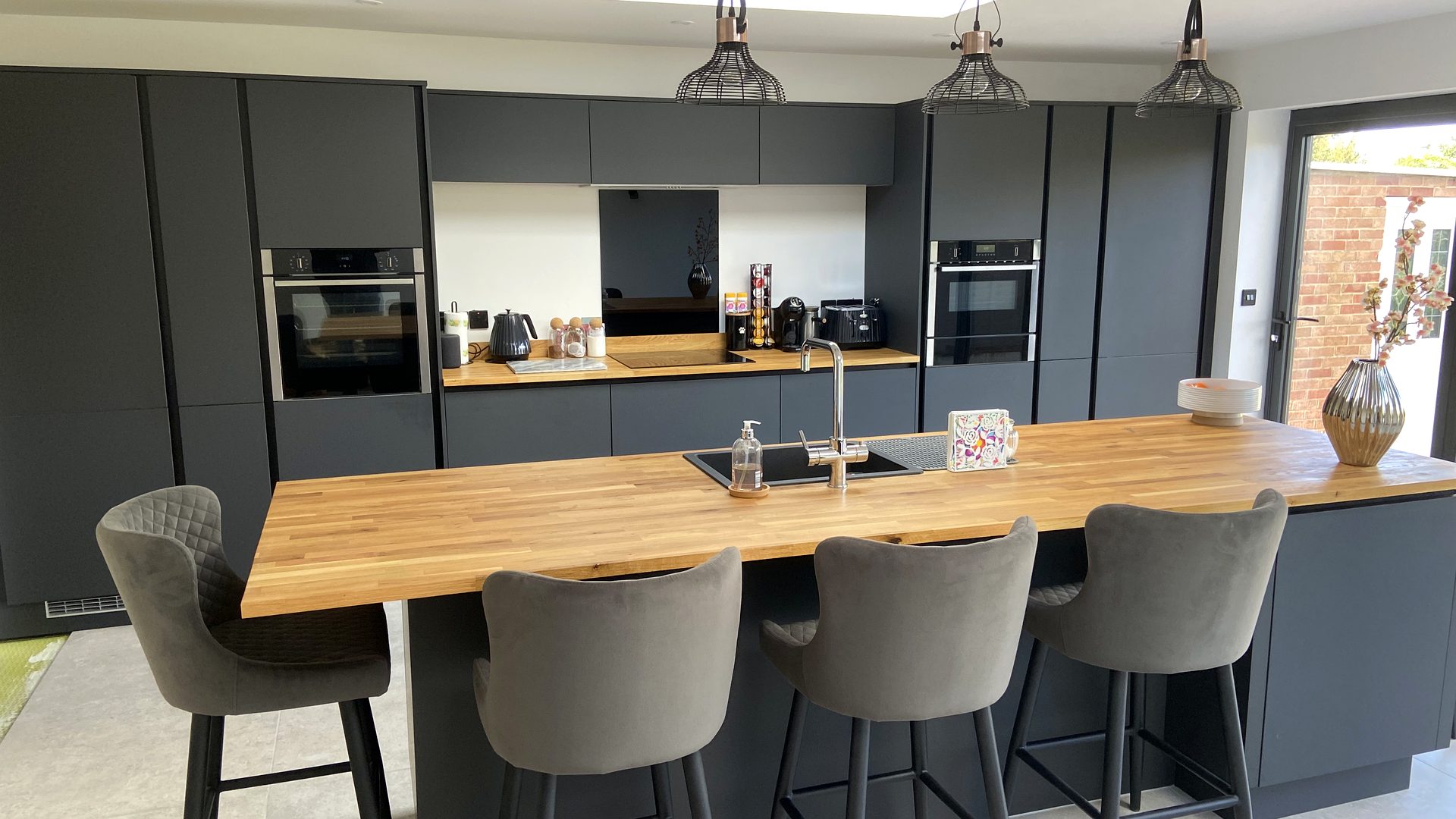 Open-plan kitchen with solid oak breakfast bar, hand-fitted by PJA