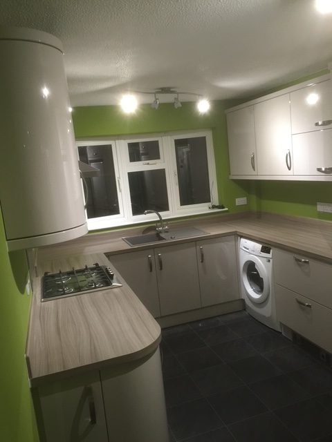 Cream gloss kitchen with curved units and driftwood-effect worktops