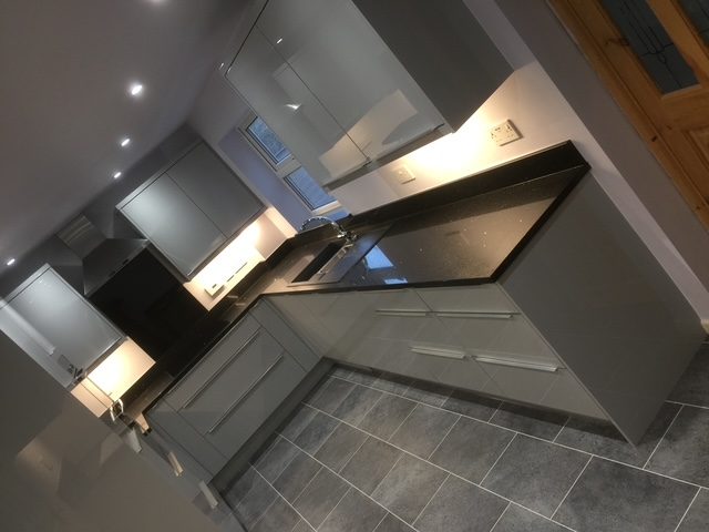Contemporary grey gloss kitchen with black quartz worktops