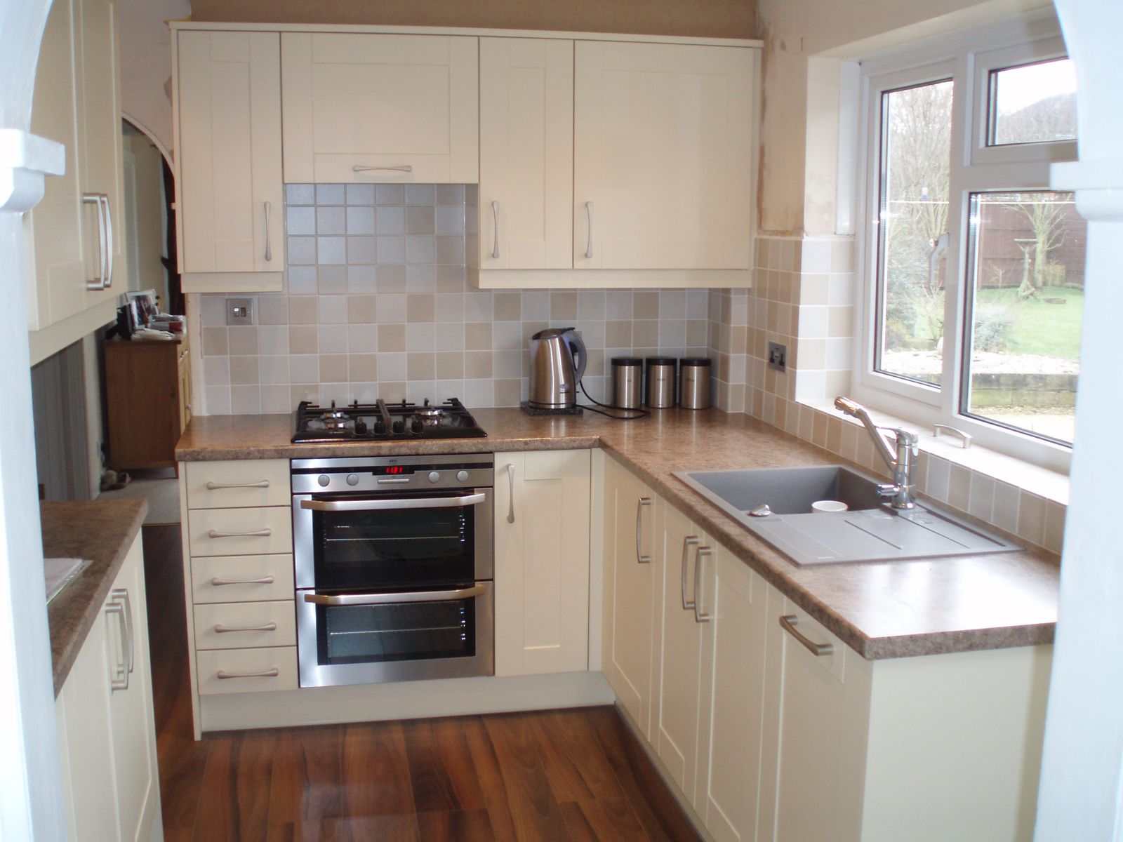 Cream kitchen with tiled splashback and double oven, Gloucester