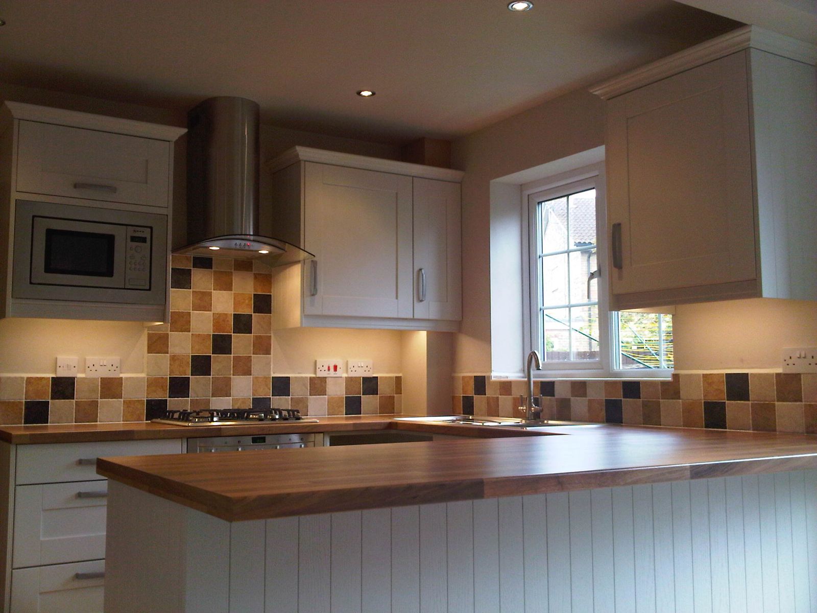 Kitchen island with breakfast bar and feature lighting