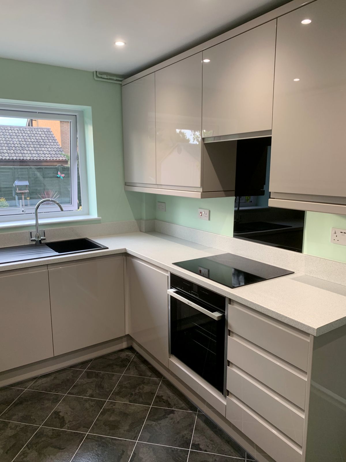 Gloss handleless kitchen with feature wall