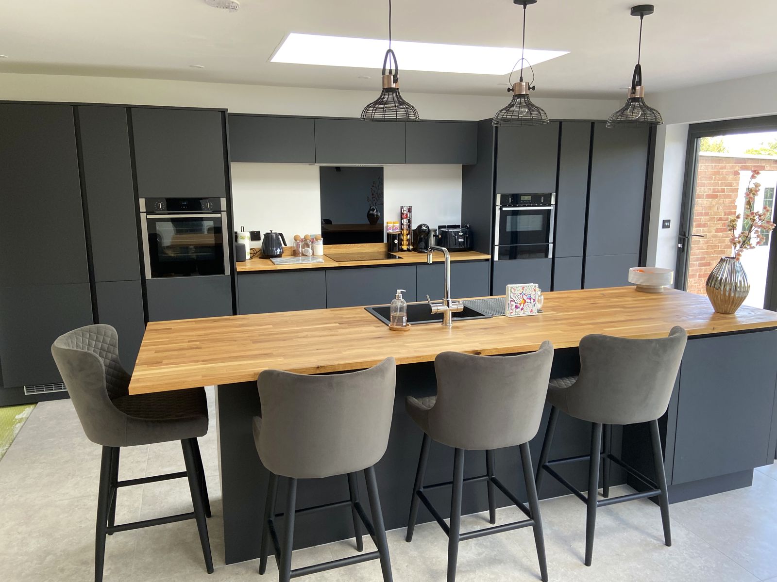 Open-plan kitchen with oak breakfast bar